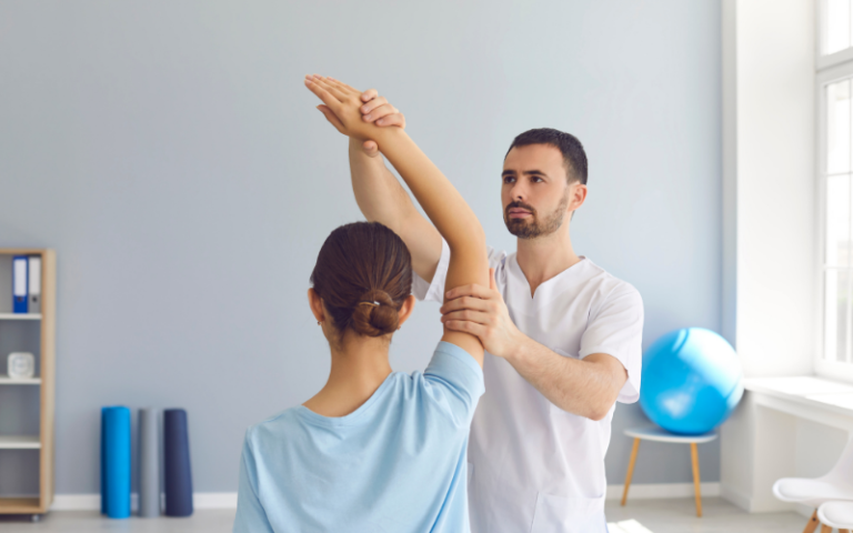 A physiotherapist in one of the clinic's rooms, treating a patients injury.